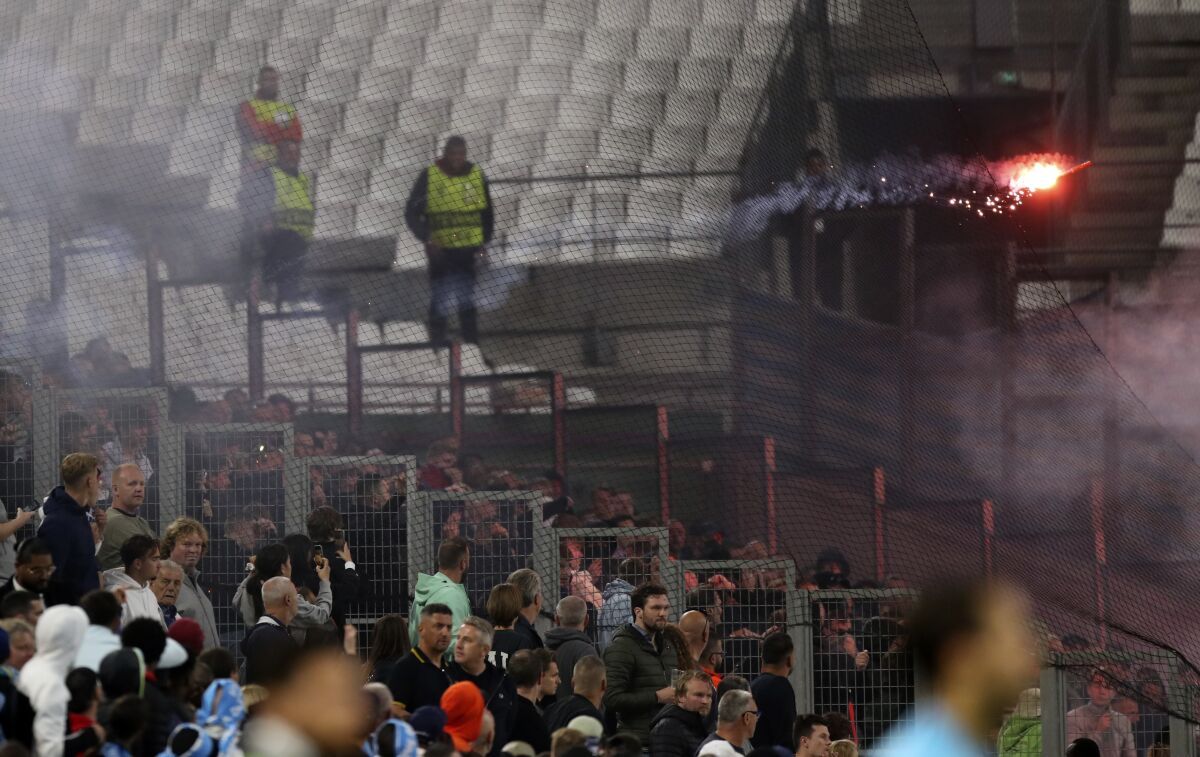 Feyenoord fans throw flares onto the pitch during the Europa Conference League semi final, second leg soccer match between Olympique Marseille and Feyenoord at the Velodrome stadium in Marseille, southern France, Thursday, May 5, 2022. (AP Photo/Daniel Cole)
