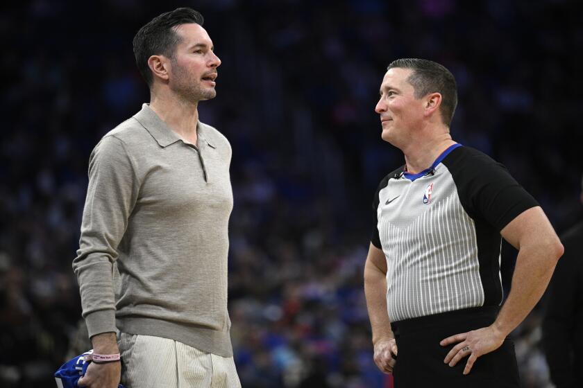 Former Orlando Magic guard JJ Redick, left, chats with official Nick Buchert on the court during a timeout in the first half of an NBA basketball game between the Magic and the New York Knicks on Wednesday, Feb. 14, 2024, in Orlando, Fla. (AP Photo/Phelan M. Ebenhack)