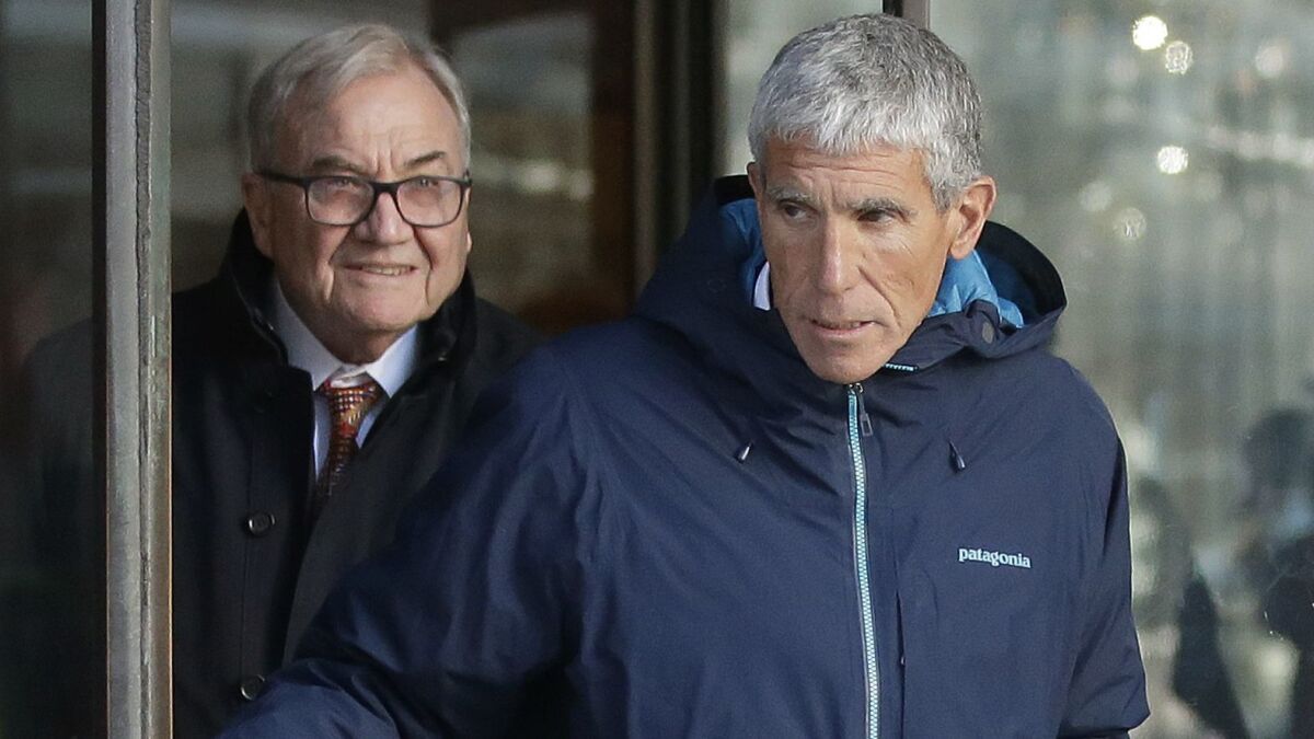 Newport Beach resident William "Rick" Singer, right, founder of the Edge College & Career Network, exits federal court in Boston on March 12 after pleading guilty to charges in a nationwide college admissions bribery scandal.