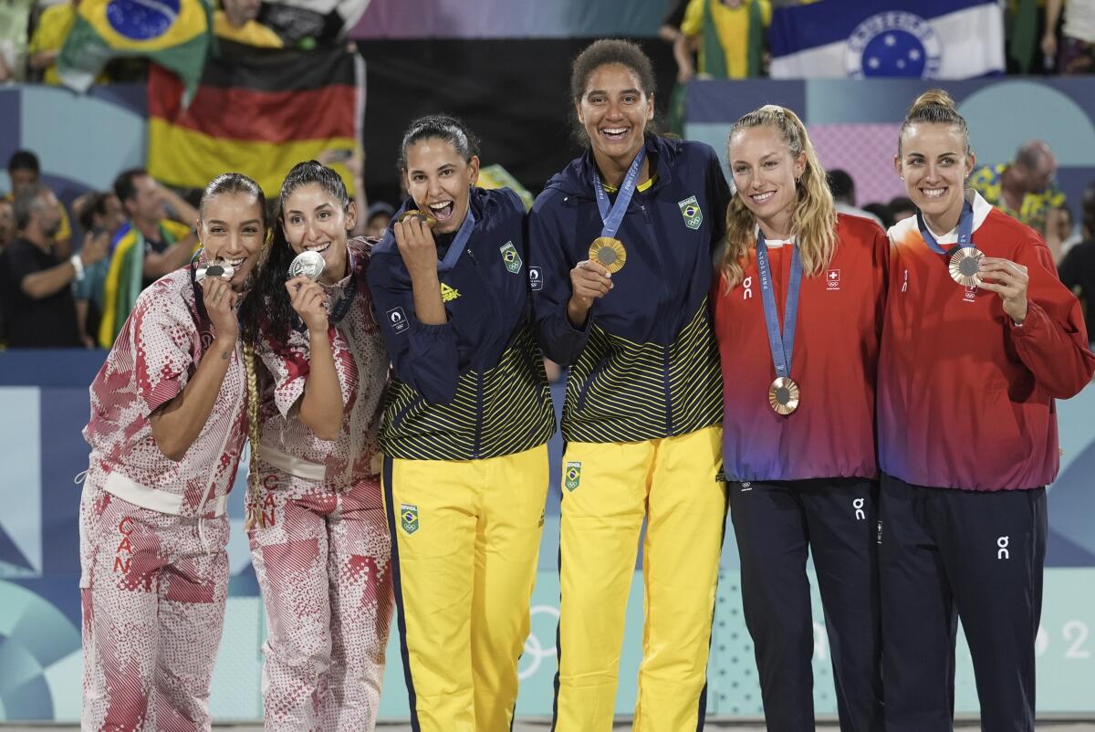 Brazil gold medalists Duda Santos Lisboa and Ana Patricia Silva Ramos pose along with other beach volleyball medalists