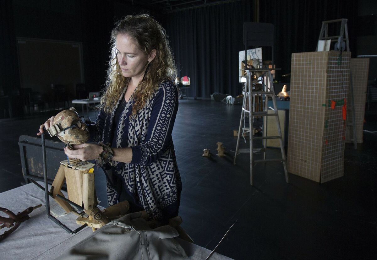 At The La Jolla Playhouse Artists Iain Gunn and Bridget Rountree are preparing to present a show called "Paper Cities." Bridget Rountree works on one of the puppets used in the show.