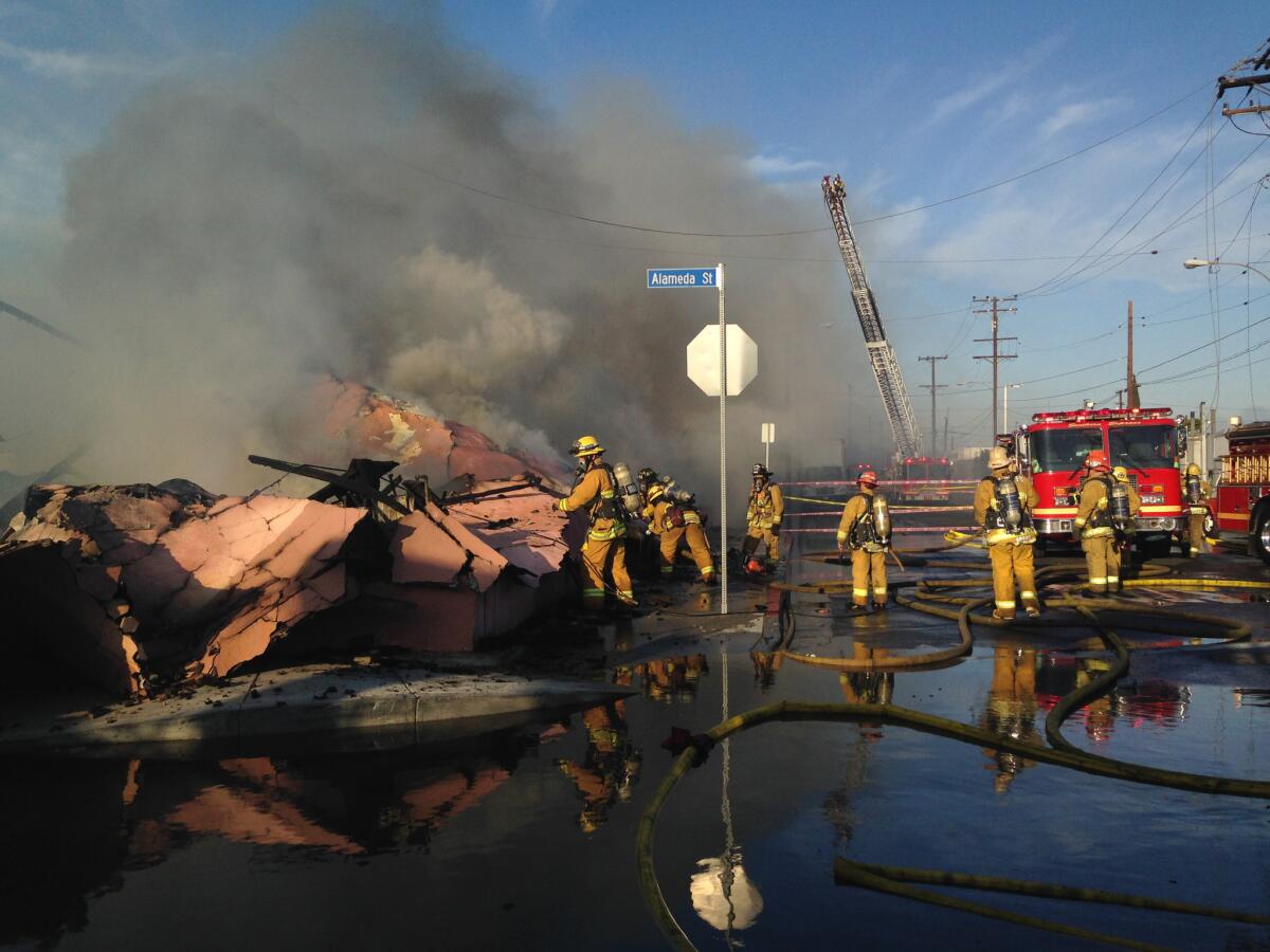 Firefighters battle a fire that engulfed a large two-story commercial structure in southeast L.A. County.