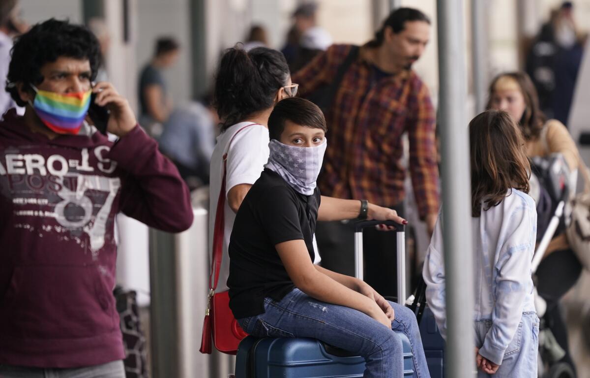 Viajeros usan mascarillas como medida de prevención contra el contagio de coronavirus en el aeropuerto Love Field, en Dallas