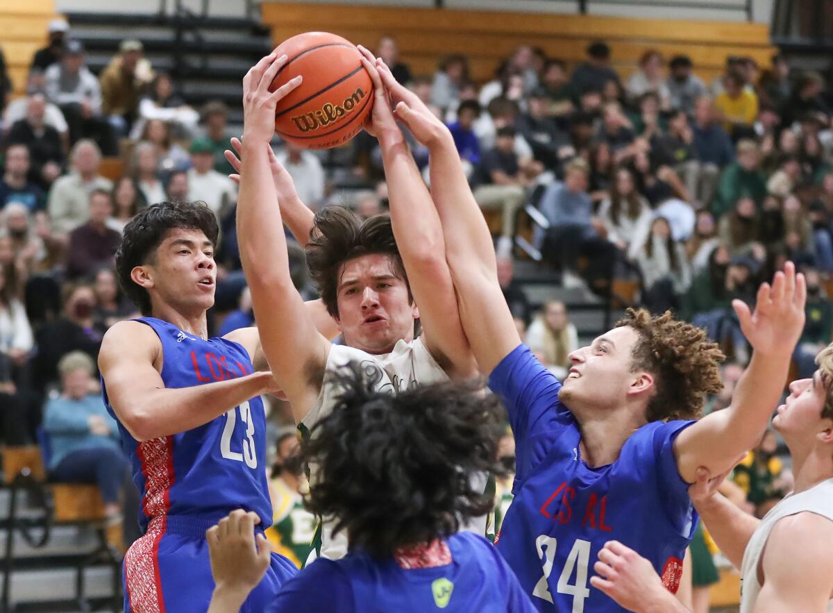 Edison's Dylan Hugues (2) grabs a hard-fought rebound during the Surf League finale against rival Los Alamitos on Thursday.