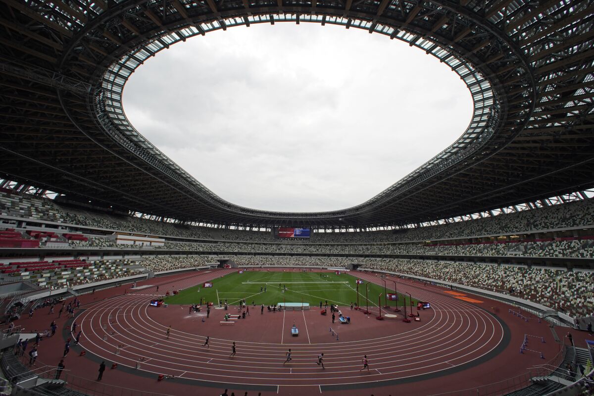In this May 11, 2021, file photo, athletes compete in the men's 400-meter T20 race during an athletics test event for the Tokyo 2020 Paralympics Games at National Stadium in Tokyo. The pandemic-delayed Tokyo Olympics are shaping up as a TV-only event with few fans — if any — being allowed when they open in just over two weeks. Japan's Asahi newspaper, citing multiple unidentified government sources, says the opening ceremony will be limited only to VIP guests. (AP Photo/Shuji Kajiyama, File)