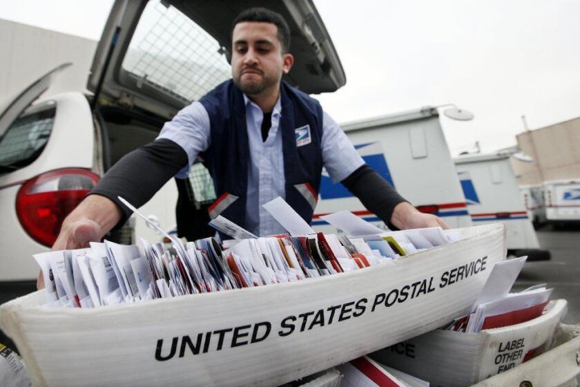 Letter carrier Felipe Raymundo moves a tray of mail to his truck to begin delivery Monday, Dec. 5, 2011, at a post office in Seattle. The cash-strapped U.S. Postal Service said Monday it is seeking to move quickly to close 252 mail processing centers and slow first-class delivery next spring, citing steadily declining mail volume. The cuts are part of $3 billion in reductions aimed at helping the agency avert bankruptcy next year. The plant closures are expected to result in the elimination of roughly 28,000 jobs nationwide. (AP Photo/Elaine Thompson)