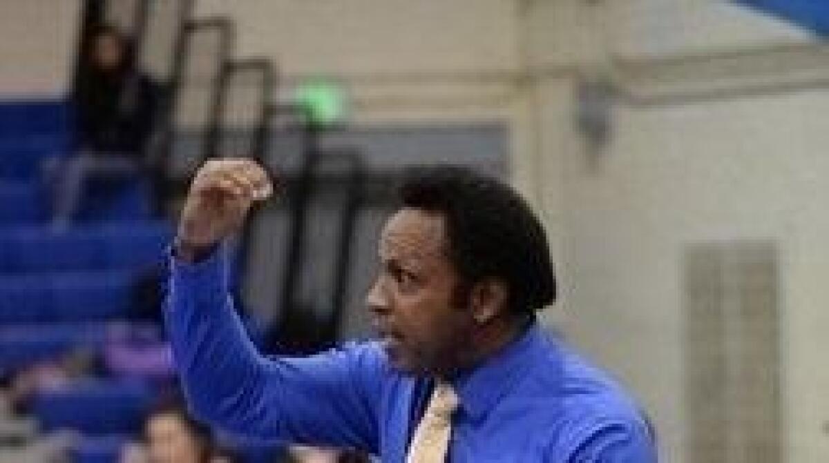 Terry Gillard raises an arm while standing in a gym.