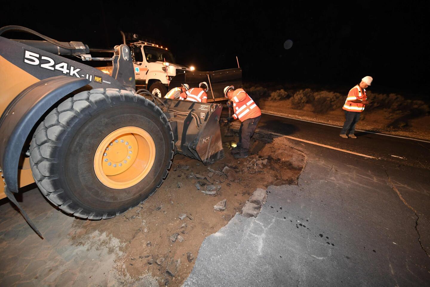 Trabajadores reparan un agujero que se abrió en la carretera como resultado del terremoto del 5 de julio de 2019 en Ridgecrest, California, a unas 150 millas (241 km) al norte de Los Ángeles.