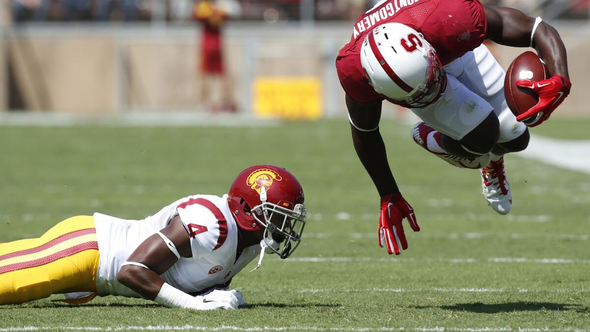 USC cornerback Chris Hawkins, left, trips up Stanford wide receiver Ty Montgomery during the Trojans' win on Sept. 6.