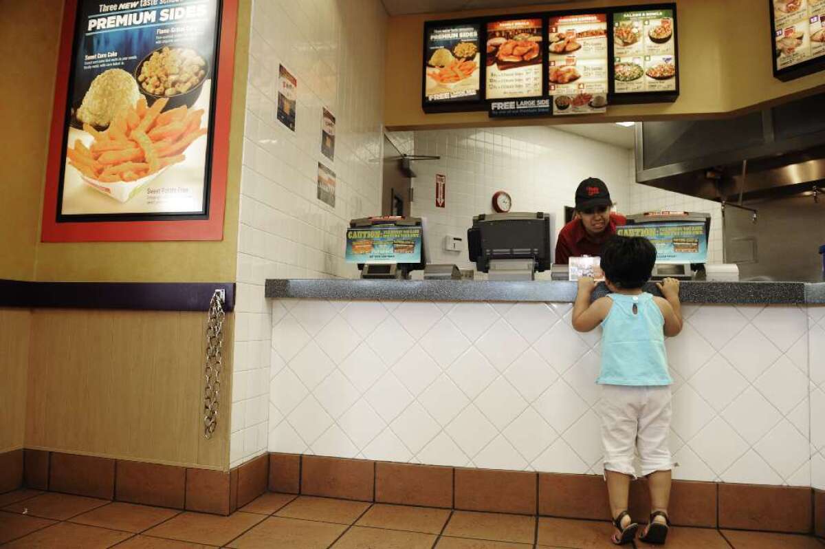 One-third of U.S. kids eat fast food on a typical day, according to a new report from the Centers for Disease Control and Prevention. Above, a little girl requests a packet of sauce at an El Pollo Loco restaurant in Santa Ana.