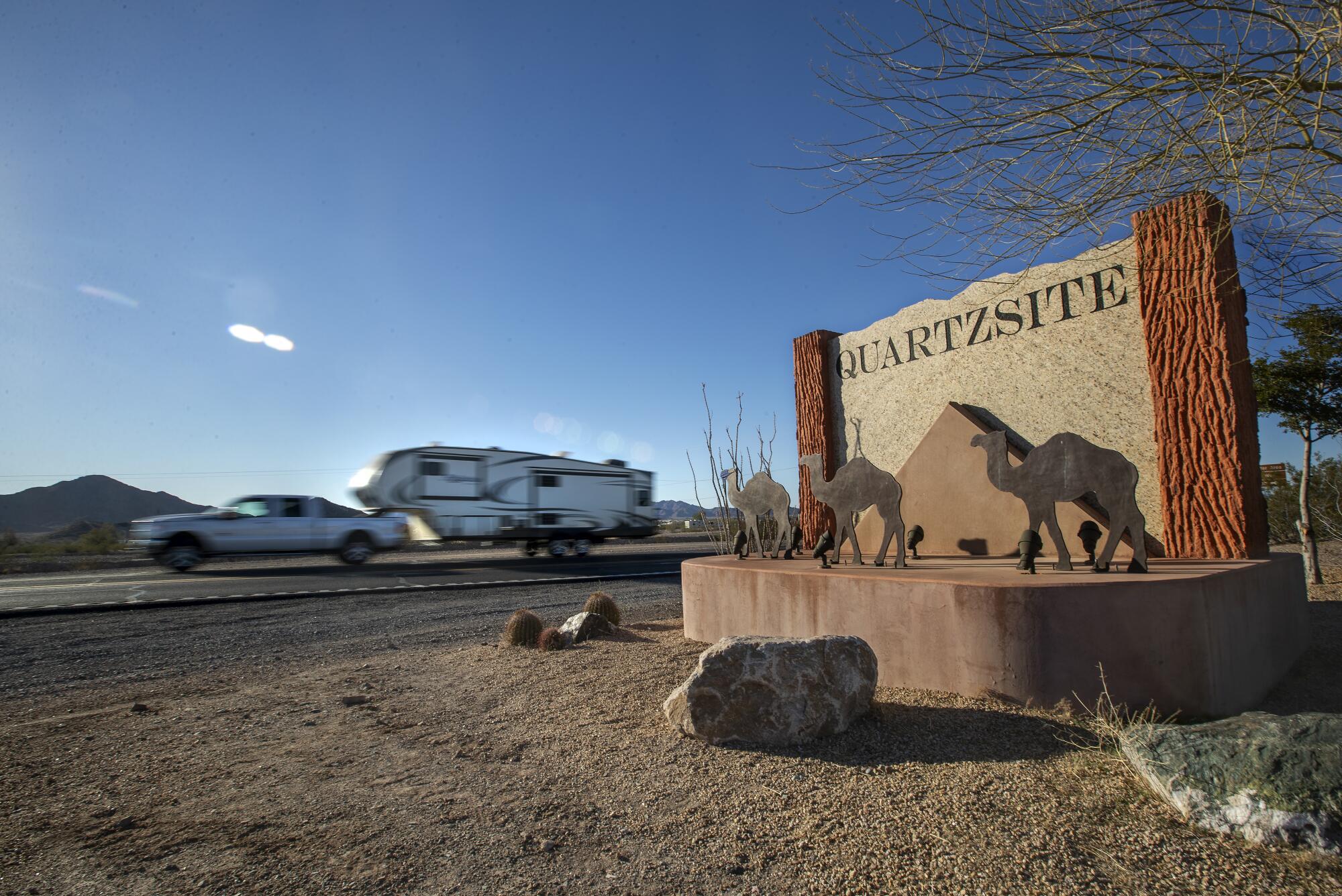 A vehicle drives past a sign for Quartzsite, Ariz. 