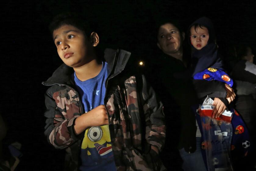 After crossing the Rio Grande River at night with the help of smugglers, women and children from Central America are detained by U.S. Border Patrol agents.