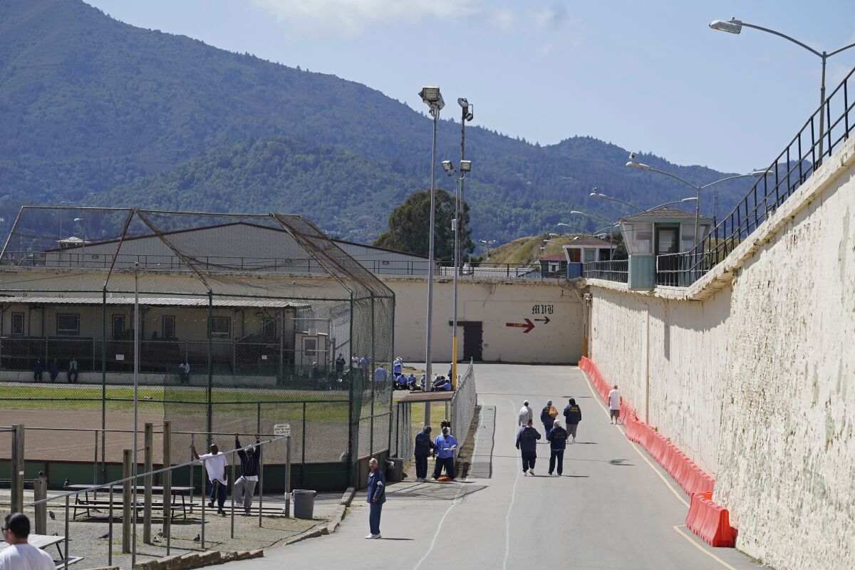 Inmates walk around the exercise yard at San Quentin State Prison on April 12, 2022.