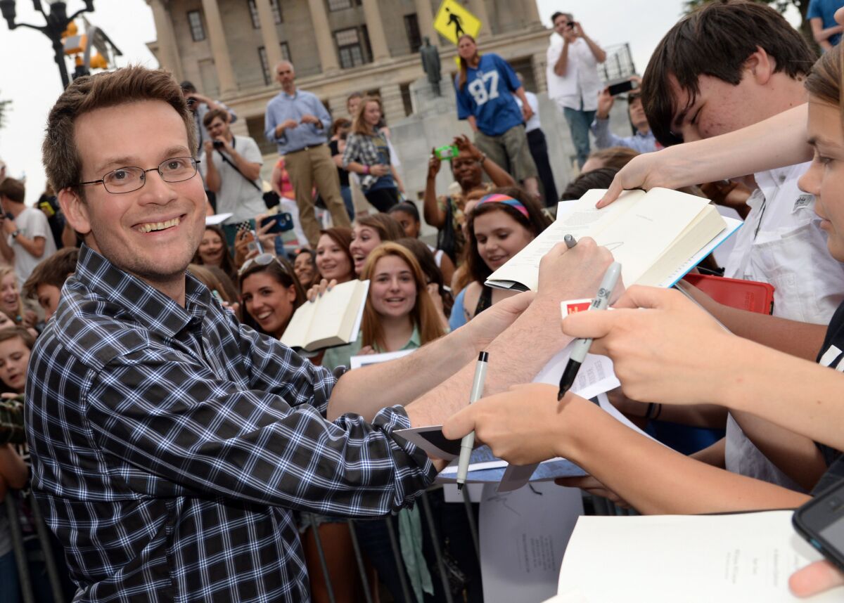 John Green signs books for fans of "The Fault In Our Stars." He'll drive a race car on the Indianapolis Motor Speedway next month.
