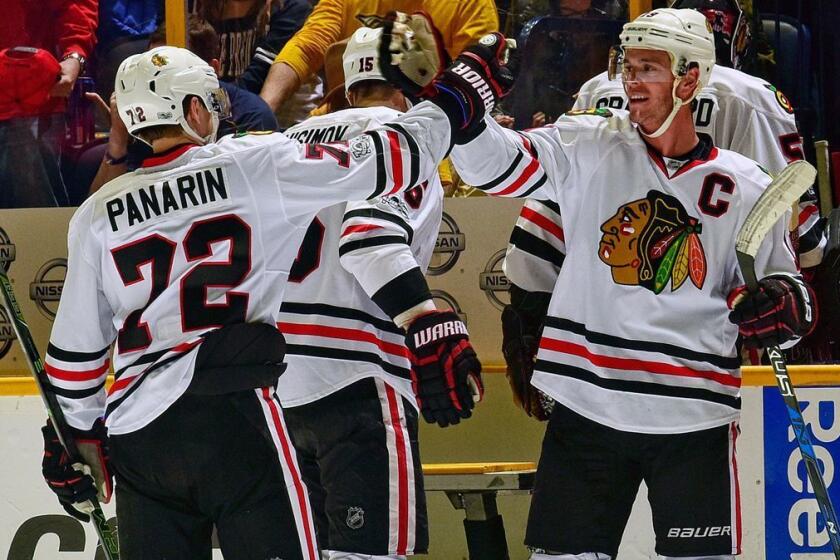 The Chicago Blackhawks' Jonathan Toews, right, high-fives teammate Artemi Panarin after a 5-3 victory over the Nashville Predators on Saturday.