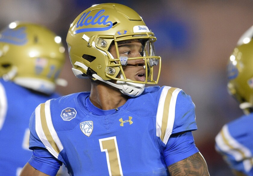UCLA quarterback Dorian Thompson-Robinson is about to throw a football during a game.