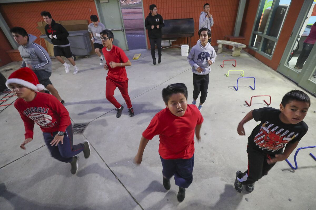 Boys with the Imperial Boxing Youth Athletics Club run in place as they workout at the Dolores Magdaleno Recreation Center in Logan Heights on Thursday, December 19, 2019.