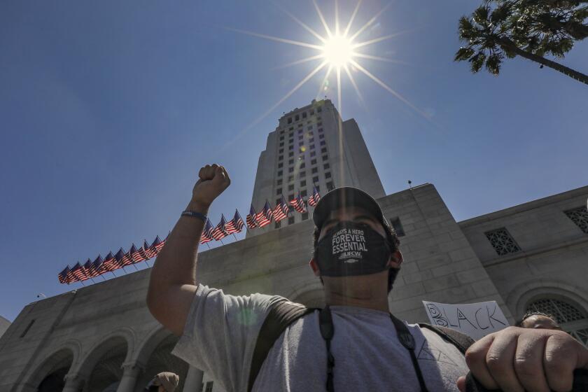 LOS ANGELES, CA - JUNE 04: Eduardo Realegeno, 18, joins protest over police brutality and the death of George Floyd taking place in front of Los Angeles City Hall City Hall on Thursday, June 4, 2020 in Los Angeles, CA. (Irfan Khan / Los Angeles Times)