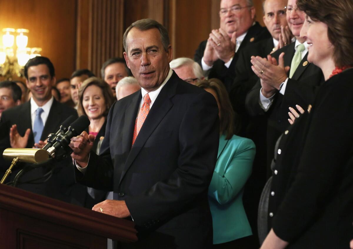 House Speaker John A. Boehner celebrates with fellow House Republicans after a vote Friday on a spending bill that defunds Obamacare.