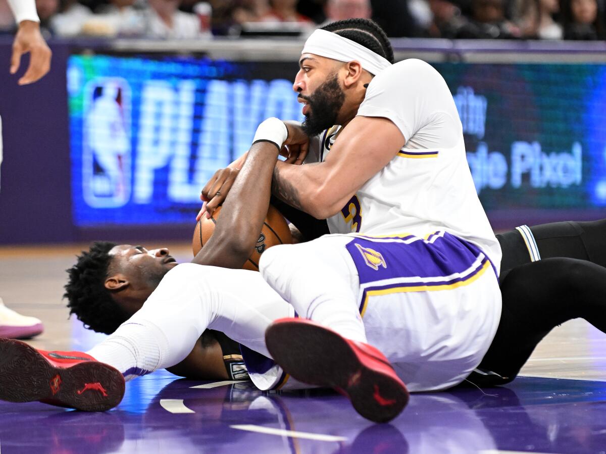 Lakers forward Anthony Davis battles or a loose ball with Grizzlies forward Jaren Jackson Jr.
