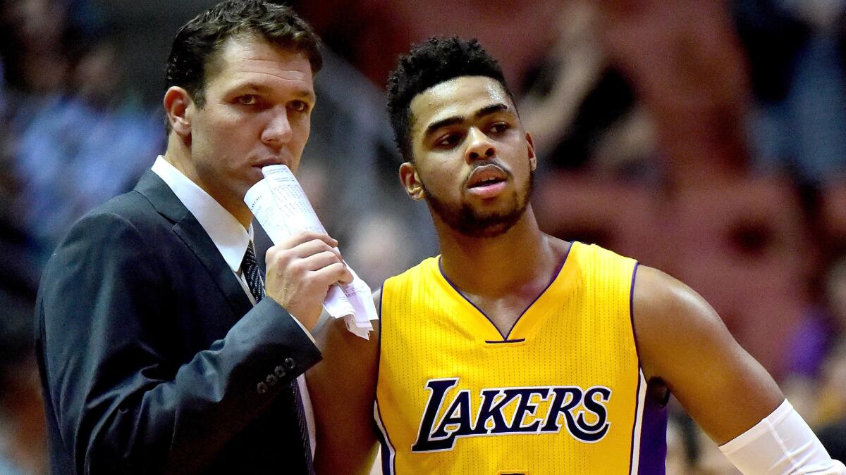 Coach Luke Walton and point guard D'Angelo Russell talk strategy during a break in a game this season.