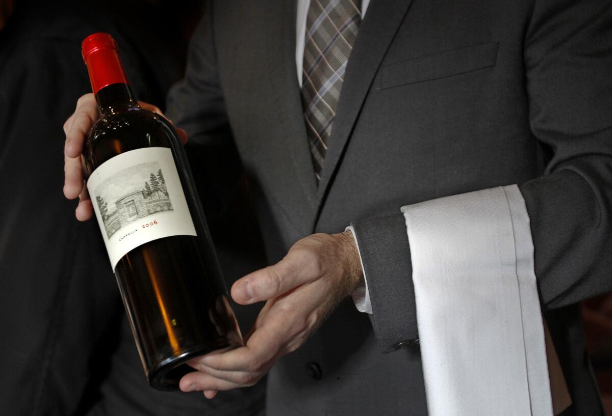 A sommelier displays a bottle of Cappella 2006 red wine. A new feature called Corkpon allows restaurants to offer discounts to customers on corkage fees.