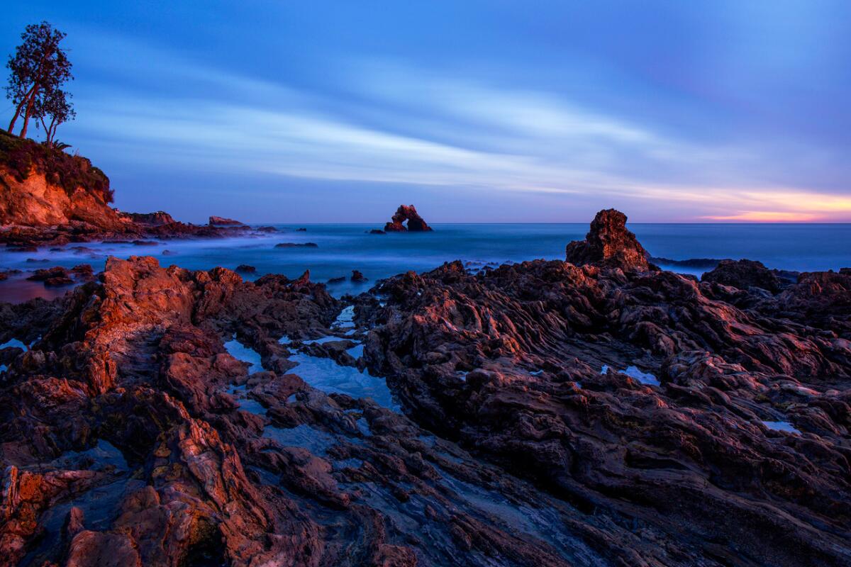 The sun sets during low tide at Little Corona del Mar Beach in Newport Beach late last year.