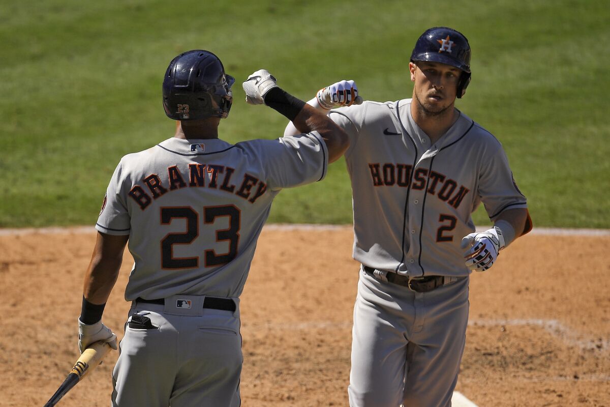 Houston Astros' Alex Bregman, right, is congratulated by Michael Brantley after hitting a solo home run during the seventh inning of a baseball game against the Los Angeles Angels Sunday, Aug. 2, 2020, in Anaheim, Calif. (AP Photo/Mark J. Terrill)