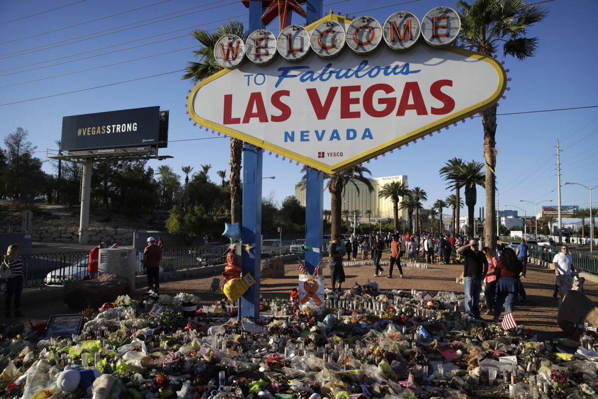 Flowers, candles and other items surround the famous Las Vegas sign at a makeshift memorial for victims of the Oct. 1 mass shooting.
