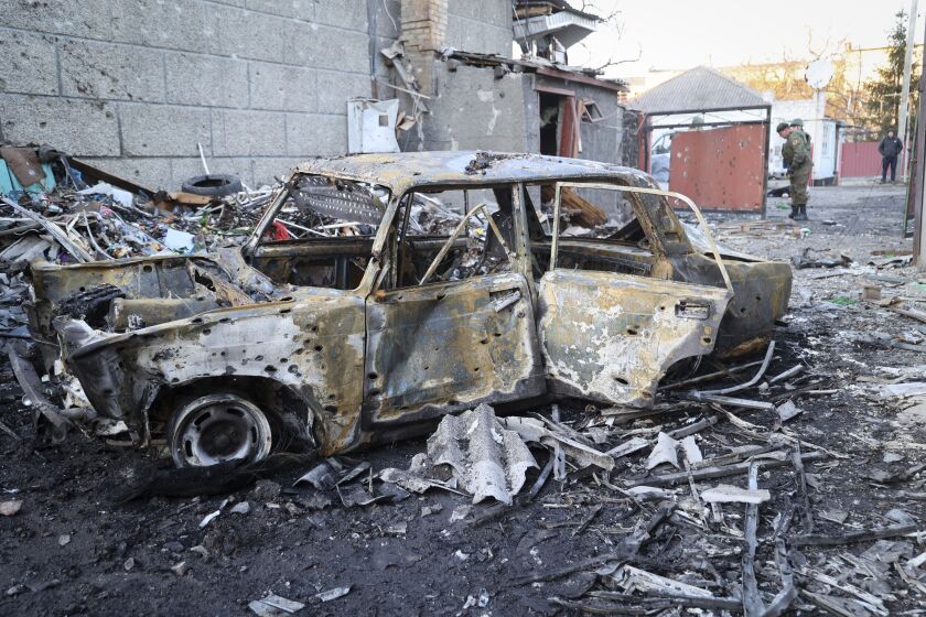 Investigadores examinan el lugar de una explosión cerca de un centro comercial, que funcionarios rusos en la región de Donetsk aseguran fue causada por artillería de las fuerzas ucranianas, el lunes 13 de marzo de 2023, en Volnovakha, región de Donetsk, en el este de Ucrania. (AP Foto/Alexei Alexandrov)