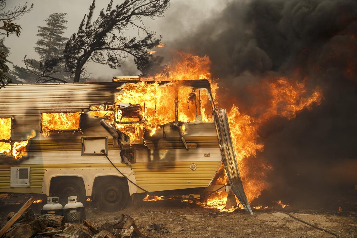 A trailer is engulfed by flames, on South Kelso Valley Road, in Weldon, Calif.