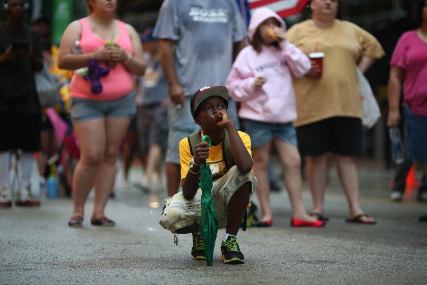 Keeland Jordan, 9, and other fans watch on State Street as Jackie Robinson West gives up three runs in the top of the first inning.