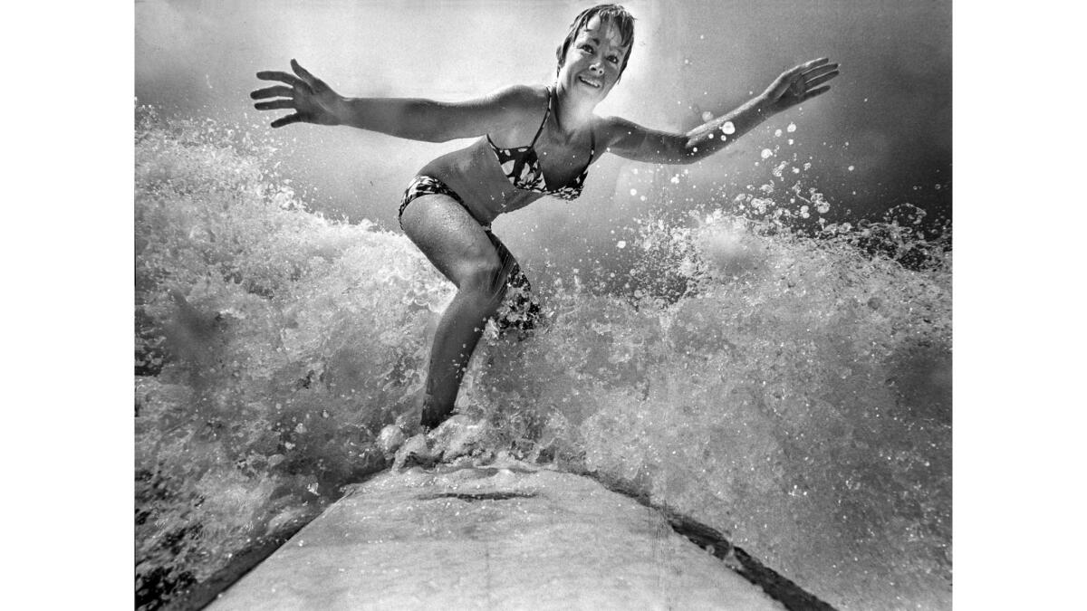 Feb. 24, 1970: Linda Benson, five-time world surfing champion, rides wave in front of her Hermosa Beach home.