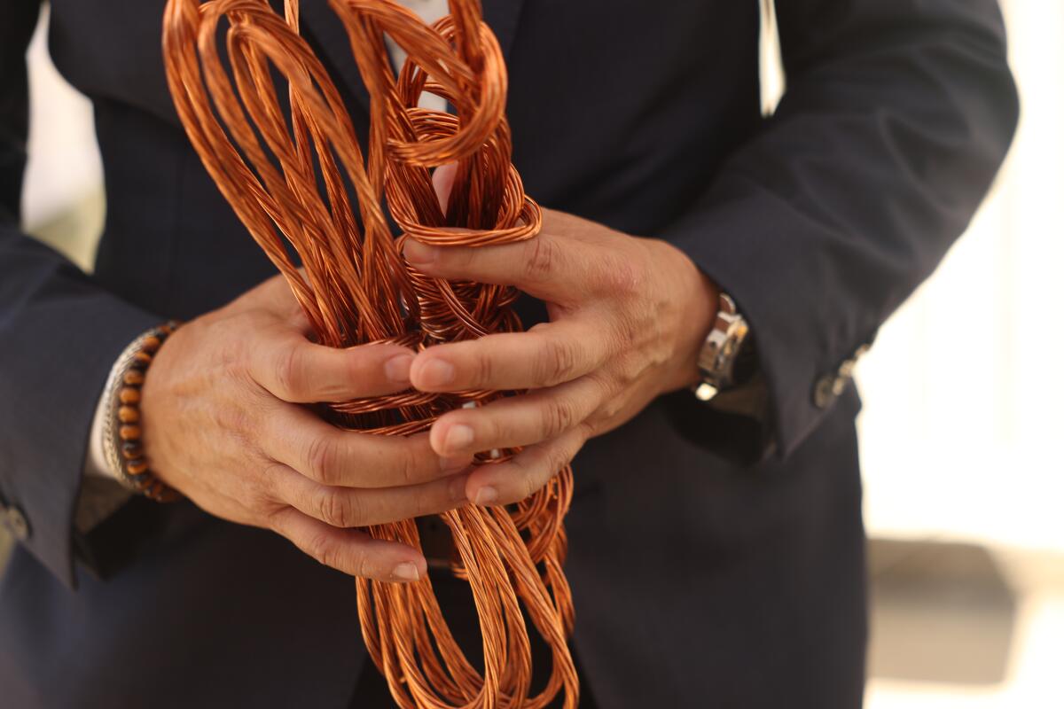 A man holds copper wire.