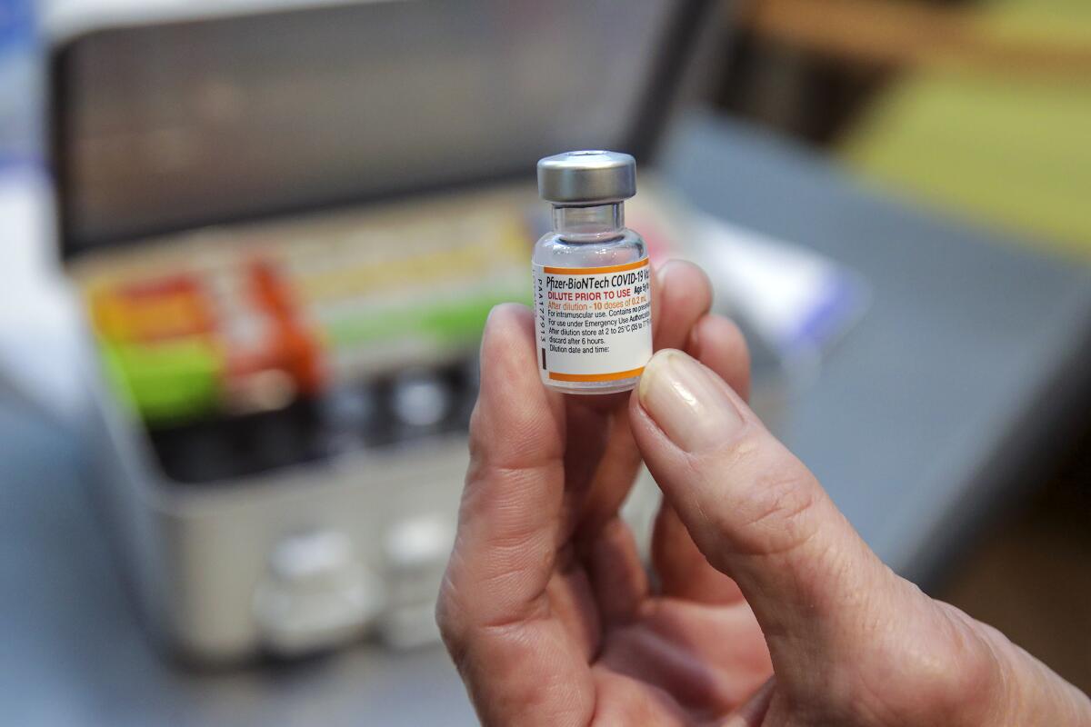  A vial of Pfizer-BioNtech Covid-19 vaccine in a hand