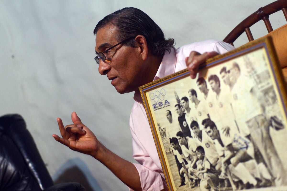 Salvador Mariona, a former soccer player for El Salvador, shows a picture of the national team during the 1970 World Cup.