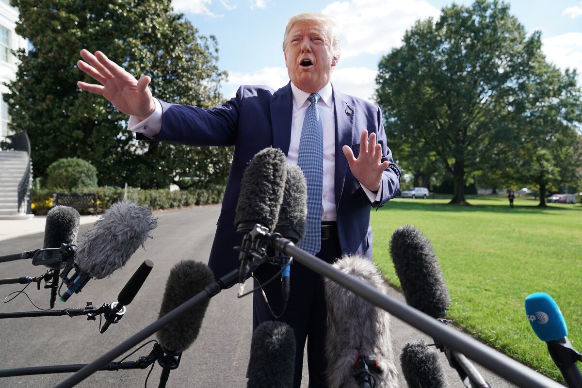President Trump talks to journalists on the South Lawn of the White House on Friday.