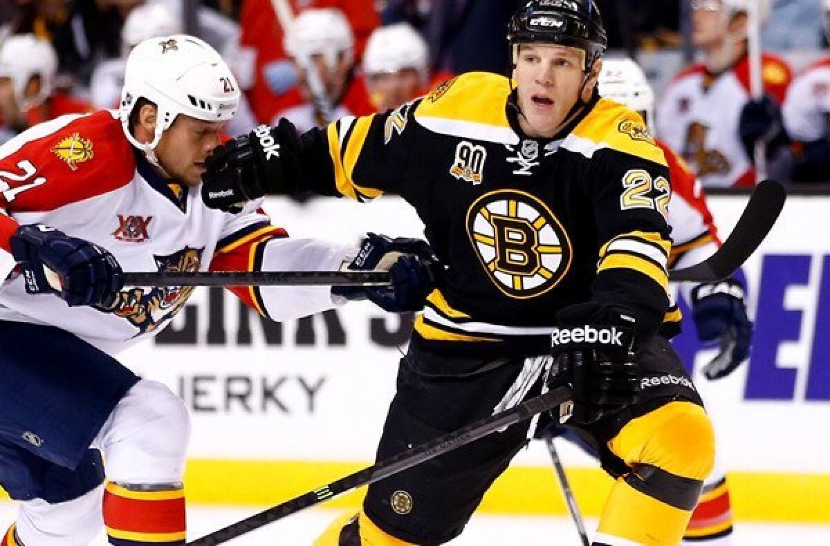 Bruins left wing Shawn Thornton looks to pass under pressure from Panthers right wing Krys Barch during a game last month in Boston.