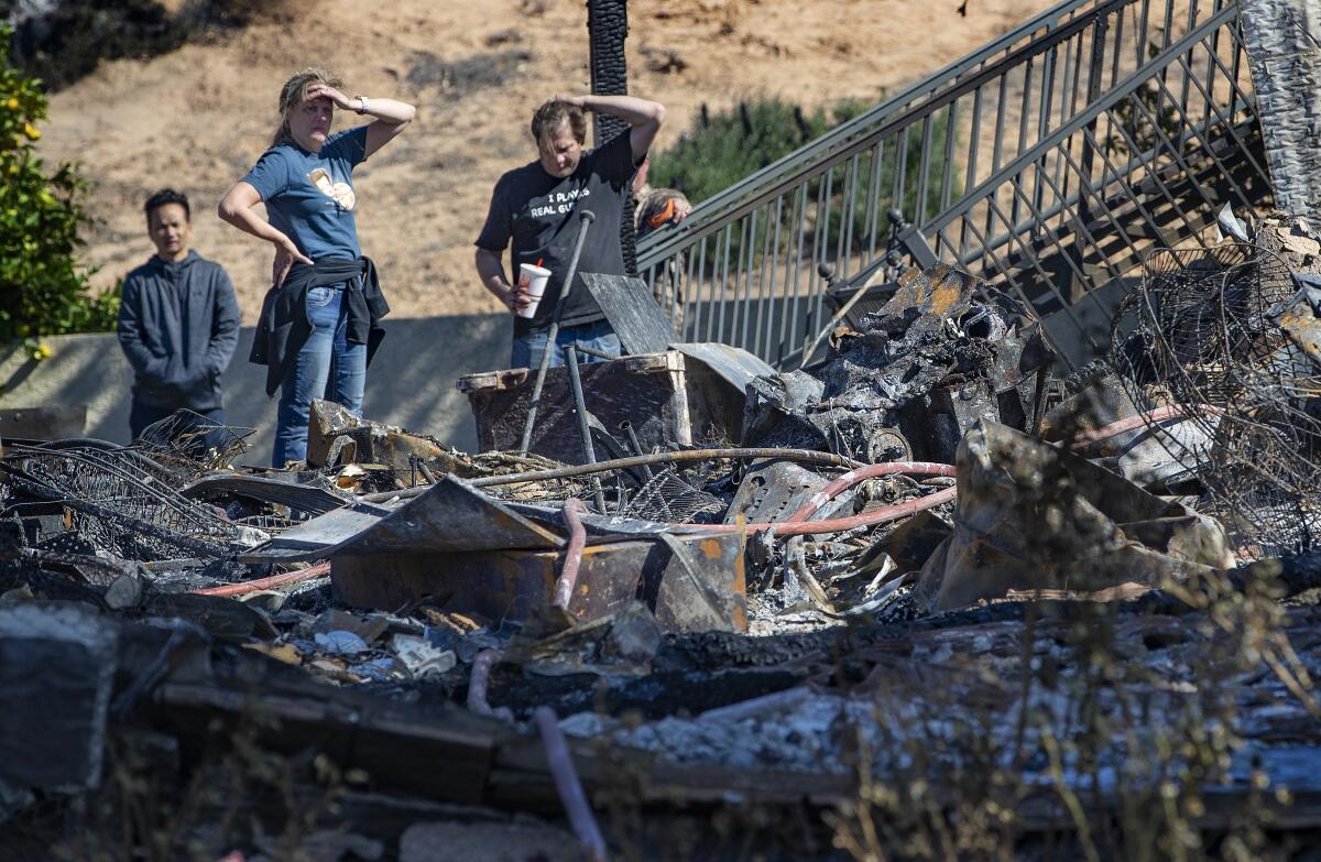 Family members view destruction of a home destroyed in the Hillside fire in San Bernardino.