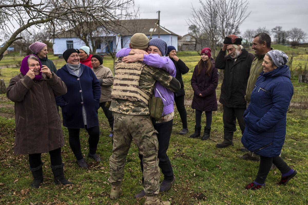 Ukrainian serviceman embracing his mother as others look on