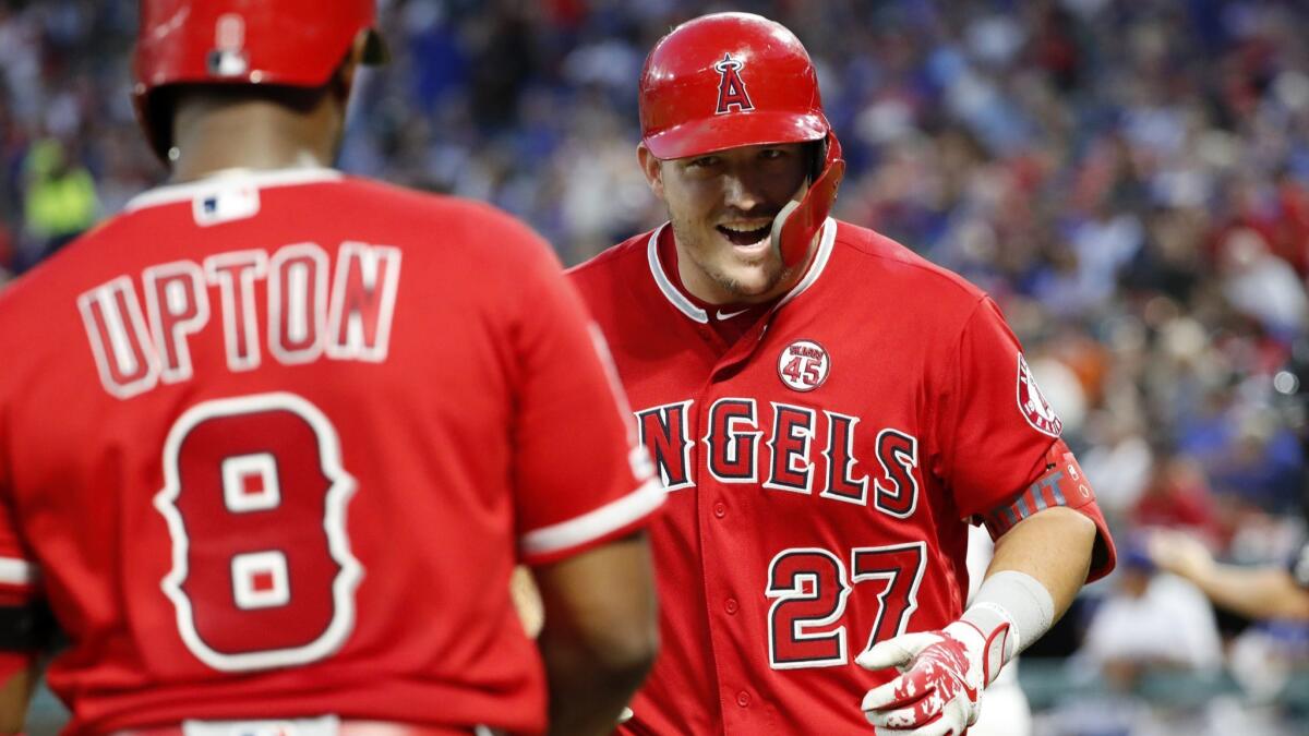 Angels' Justin Upton (8) and Mike Trout (27) celebrate Trout's solo home run during the sixth inning against the Texas Rangers in Arlington, Texas on Wednesday. The homer was Trout's second of the night.
