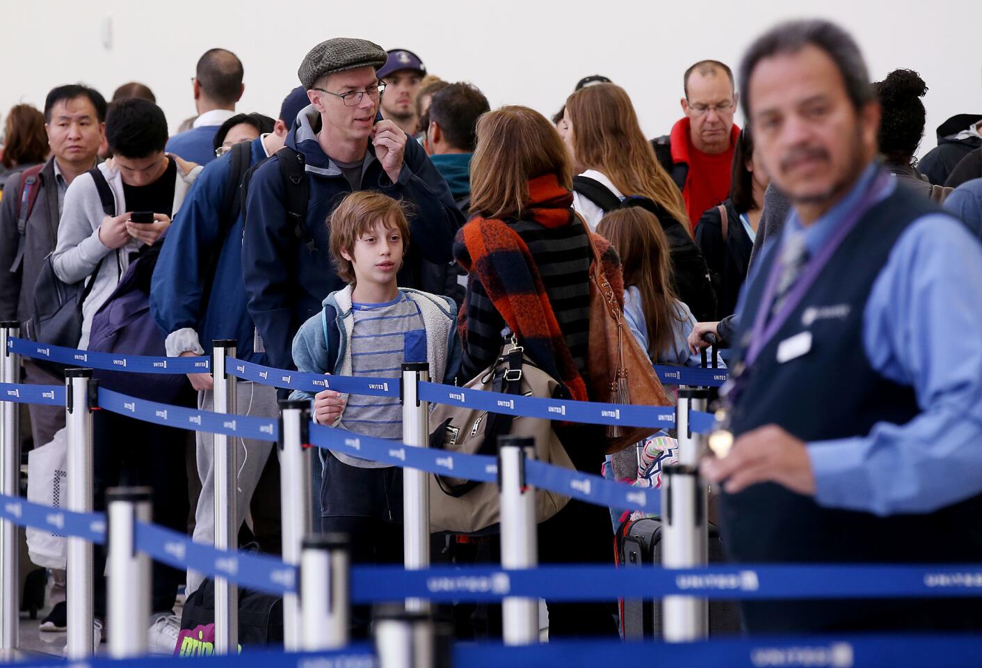 Holiday travelers line up for security screenings in Terminal 7 at LAX on Thursday. Airport officials said nearly 230 flights have been either canceled or delayed.