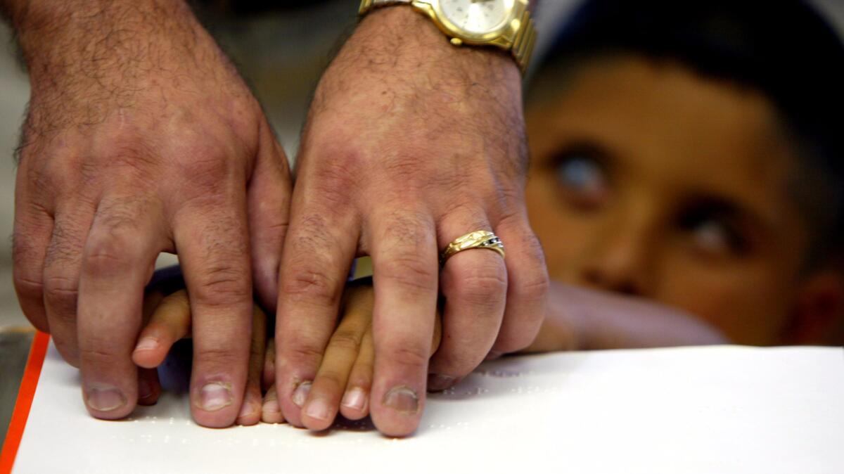 In an Anaheim classroom that draws visually impaired pupils from a wide area, Keith Christian guides Ricardo Navarro's fingers over Braille. "I am nothing special," Christian says, "but I am very determined, and I think I can model that for them."