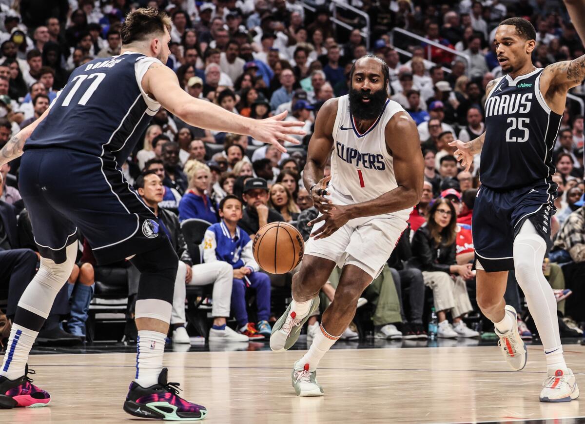 Clippers guard James Harden loses control of the ball as he drives past Mavericks guard Luka Doncic.