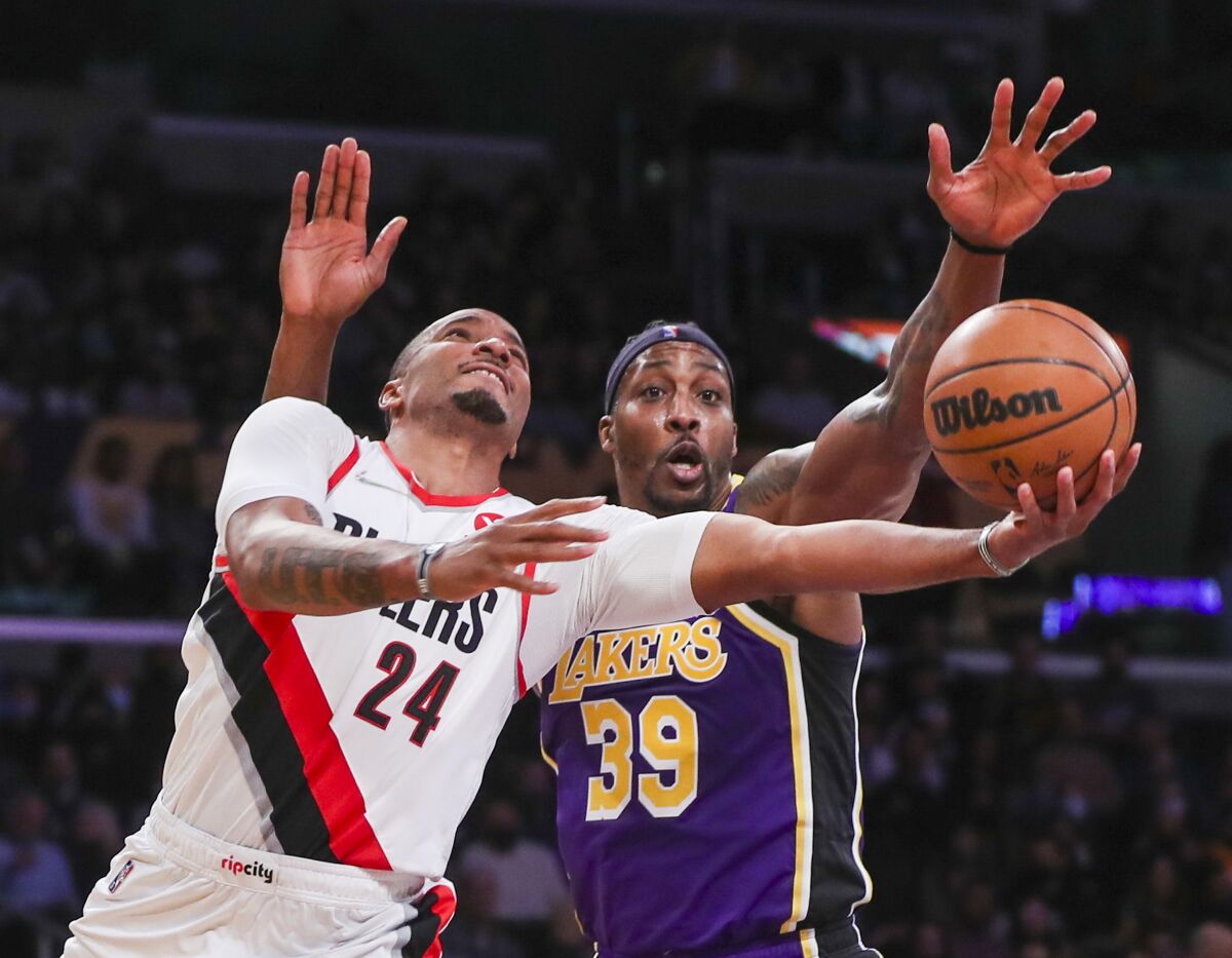 Trail Blazers guard Norman Powell tries to score on a layup against Lakers center Dwight Howard.