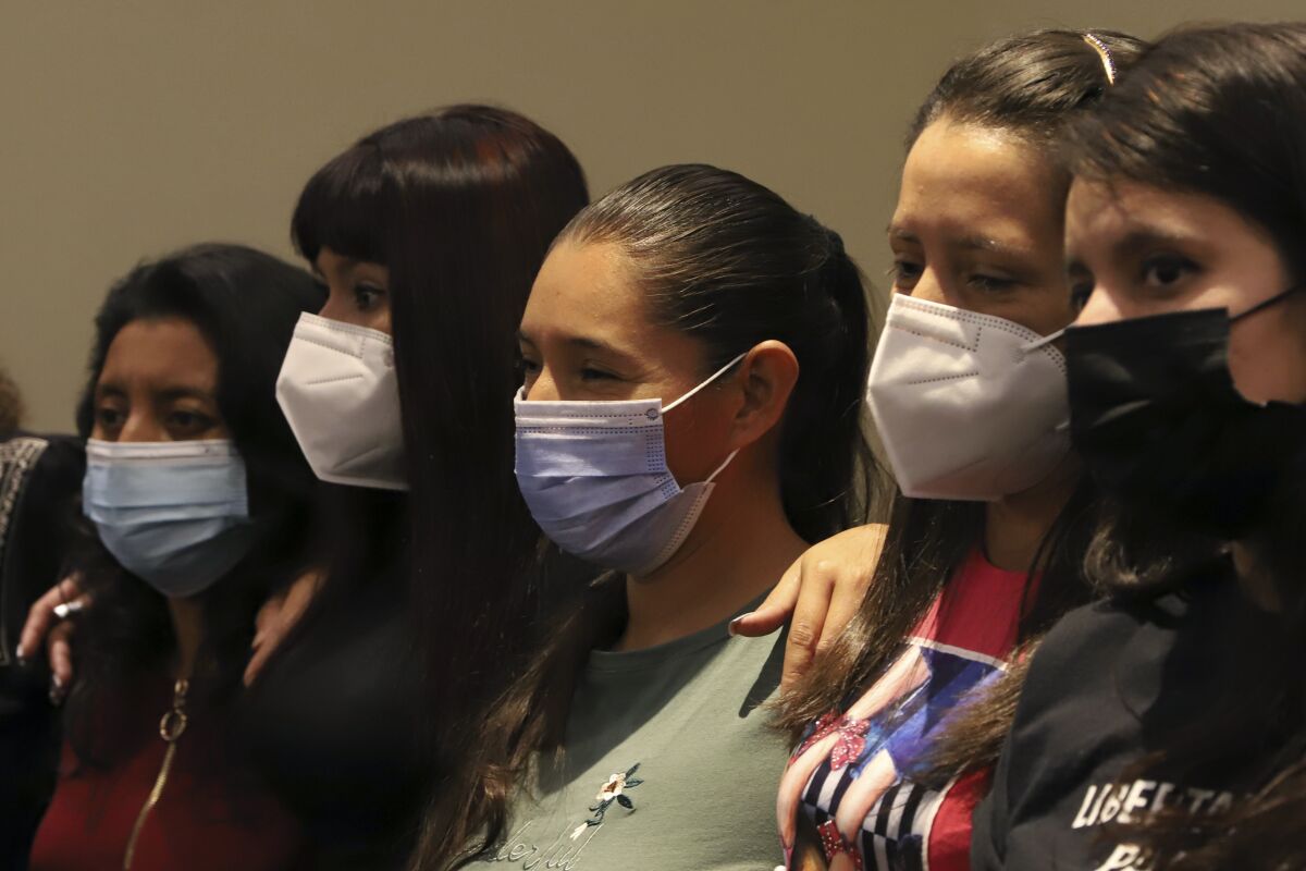 A row of women wearing face masks.