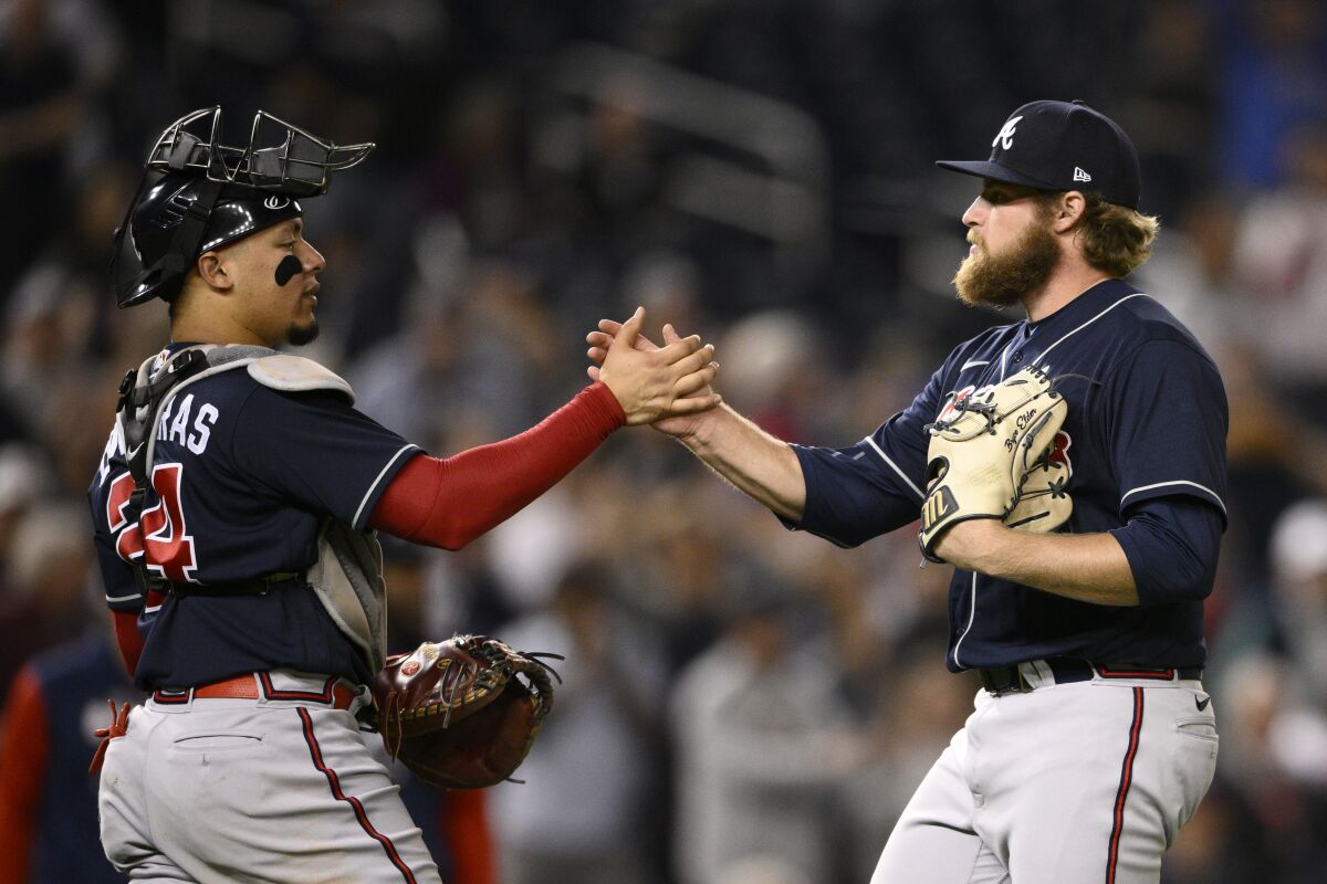 Atlanta Braves starting pitcher Bryce Elder, right, celebrates with catcher William Contreras, left, after a baseball game against the Washington Nationals, Monday, Sept. 26, 2022, in Washington. (AP Photo/Nick Wass)