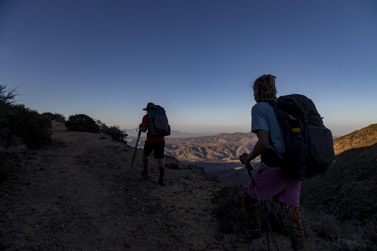  Hikers with backpacks overlooking mountains