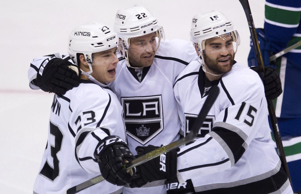 Kings right wing Dustin Brown (23) celebrates a goal with teammates Trevor Lewis (22) and Andy Andreoff (15) during the second period.