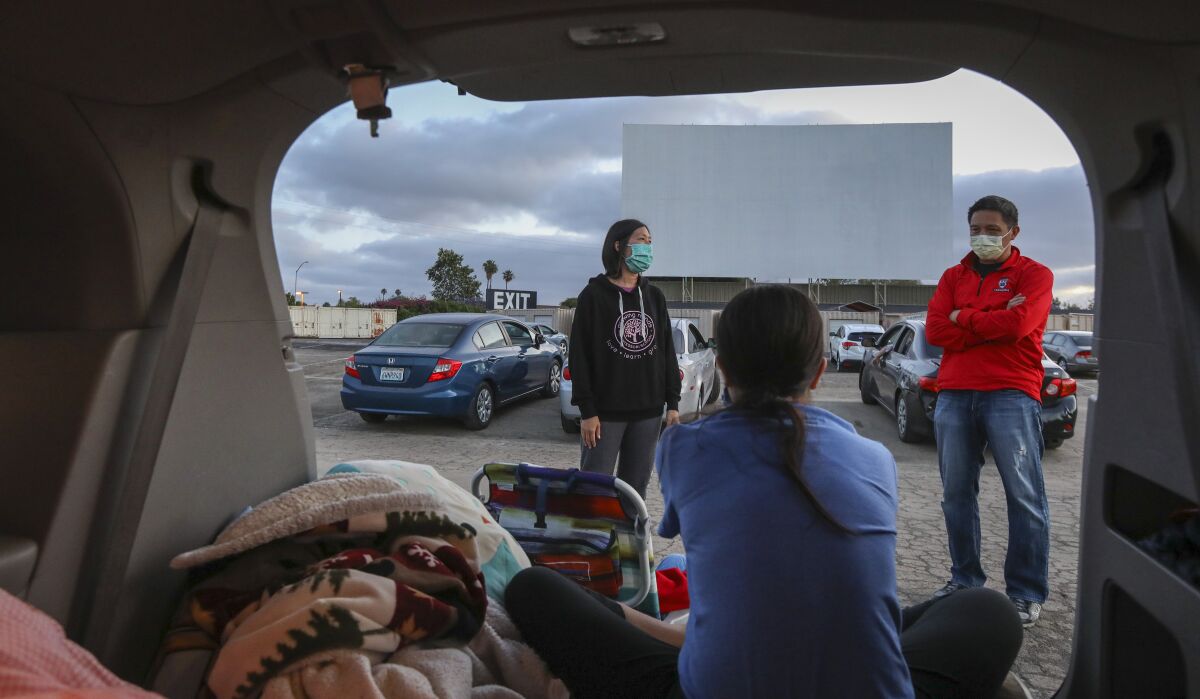 Christine Lee, left, and Tim Lee, right, wait with their daughter Eugenia, 11, to watch the movie "Trolls" at the South Bay Drive-In Theaters, which reopened last weekend.